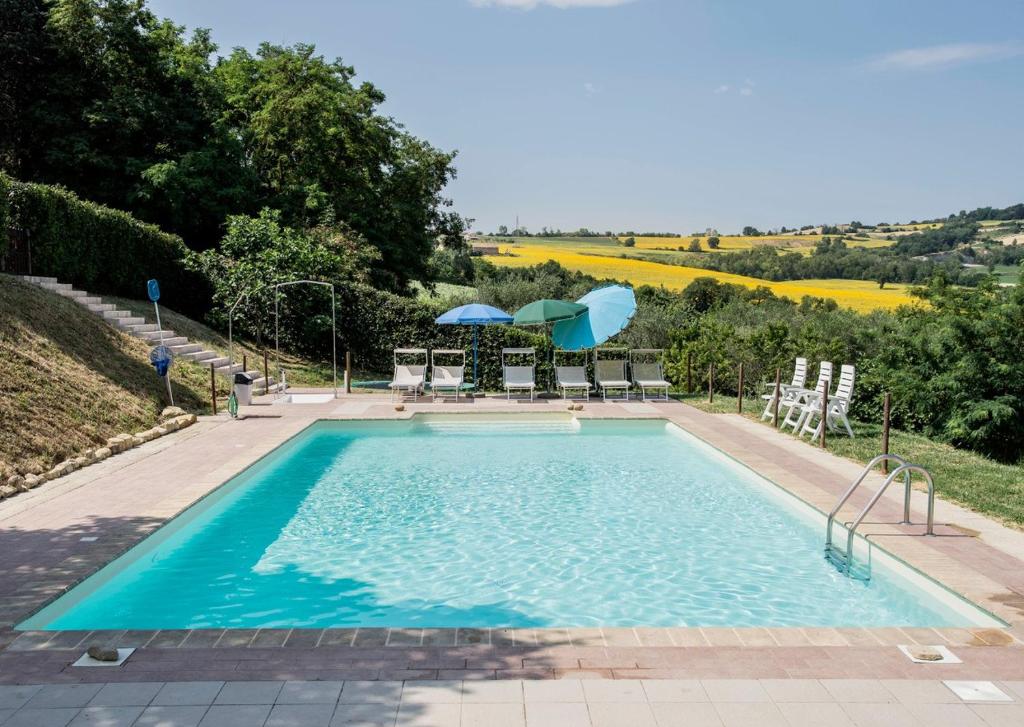 una piscina con sillas y sombrillas en una colina en Country House Montesoffio en Barchi