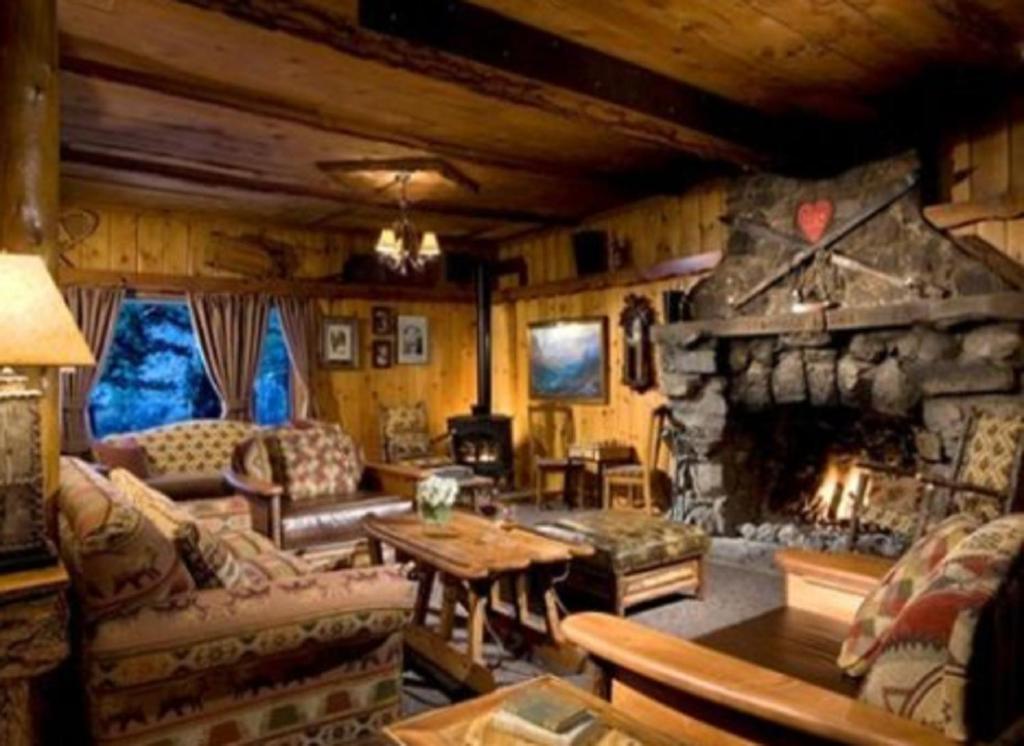 a living room with a stone fireplace in a house at Tamarack Lodge in Mammoth Lakes