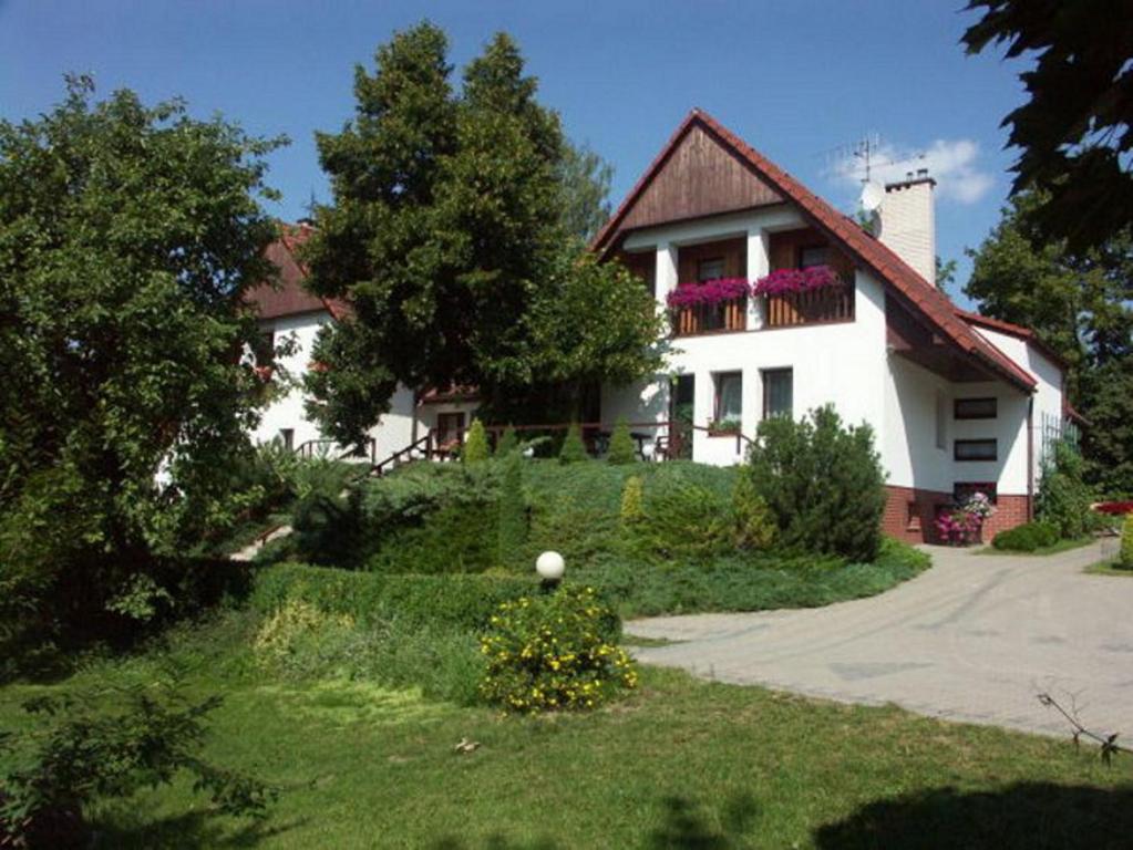 Casa blanca con porche y entrada en Pensjonat Hubertus, en Kosewo