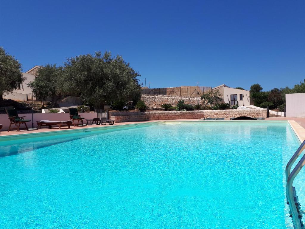 een groot zwembad met blauw water bij Agriturismo Serrafiori in Casa Serrafiori