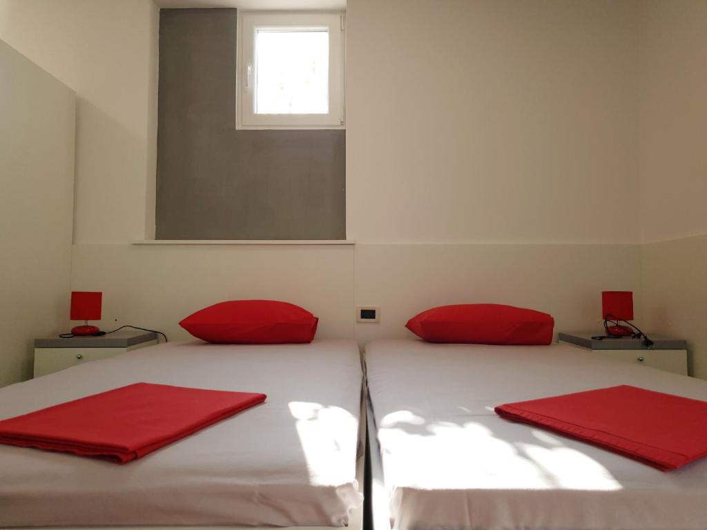 sypialnia z 2 czerwonymi poduszkami na łóżku w obiekcie Apartment Maric w Hvarze