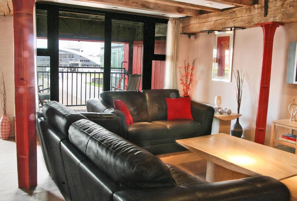 a living room with a leather couch and a table at Apartment 3, Warehouse K in London