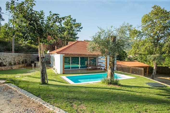 une maison avec une piscine dans une cour dans l'établissement Casa da Assudra, à Vila Verde