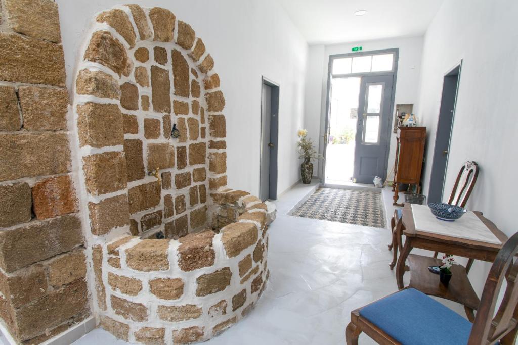 un soggiorno con parete in pietra e sedia di Mascot Boutique Hotel a Città di Rodi