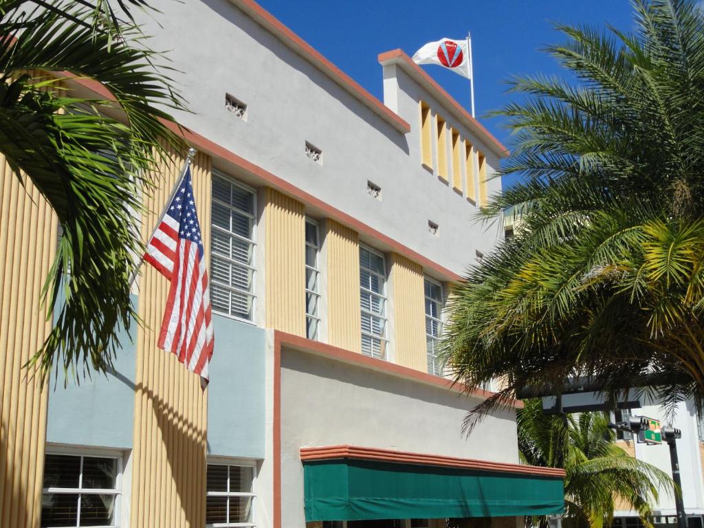 un edificio con bandera americana y palmeras en Viscay Hotel en Miami Beach