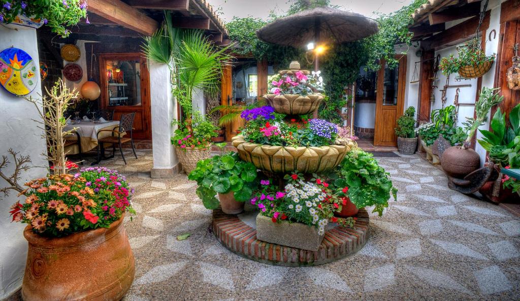 a fountain filled with lots of flowers and an umbrella at Hotel Almadraba in Zahara de los Atunes