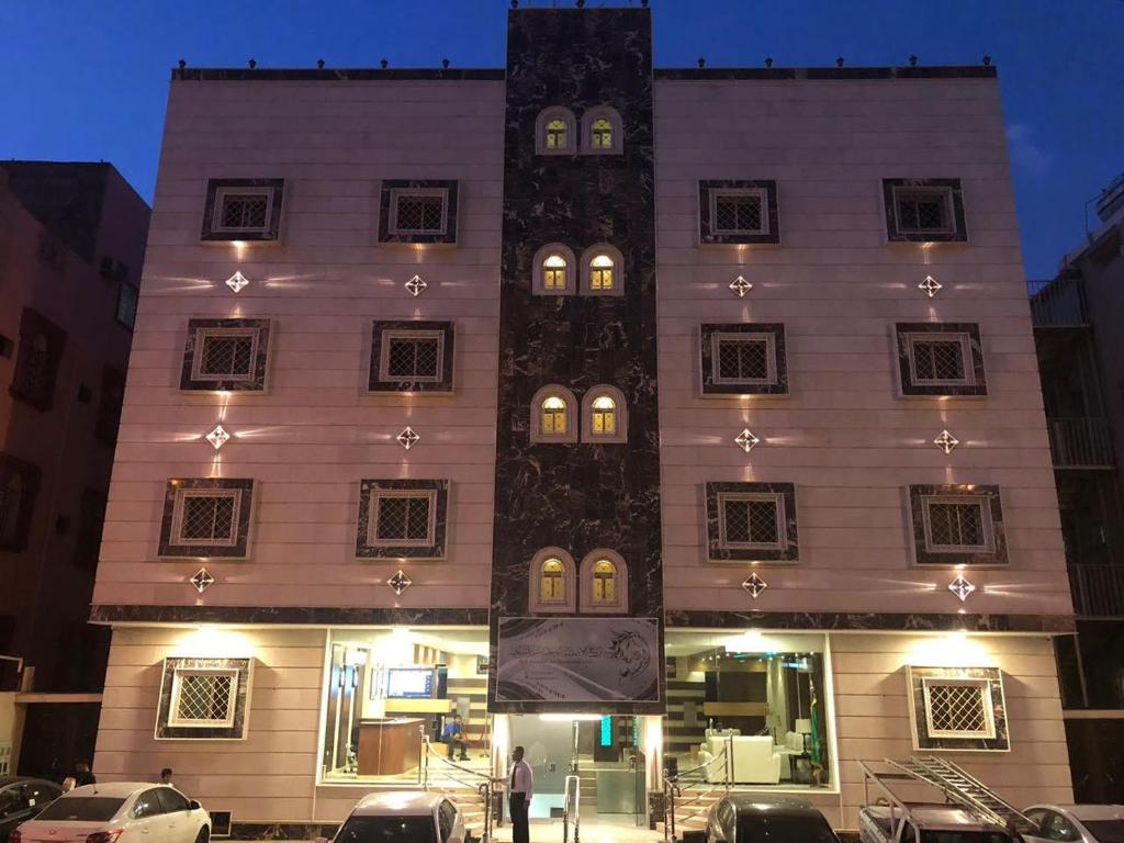 a tall white building with a clock tower at روح الأصيلة للشقق المخدومة Roh Alaseilah Serviced Apartments in Taif