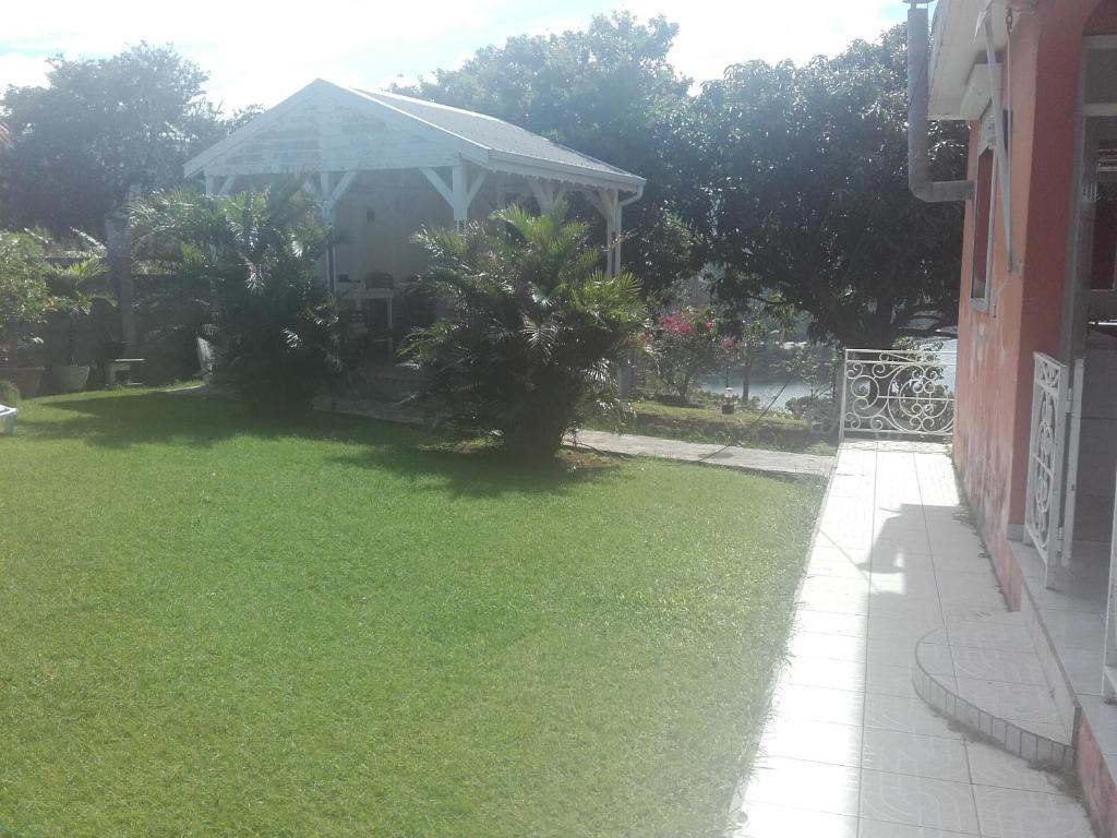 a house with a yard with green grass at Chez Antonin in Bouillante