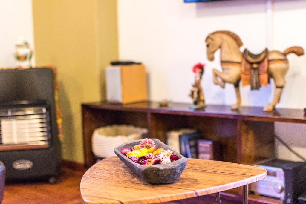 Una ciotola di caramelle su un tavolo con un giocattolo per cavalli di Departamento Inti a Cuzco