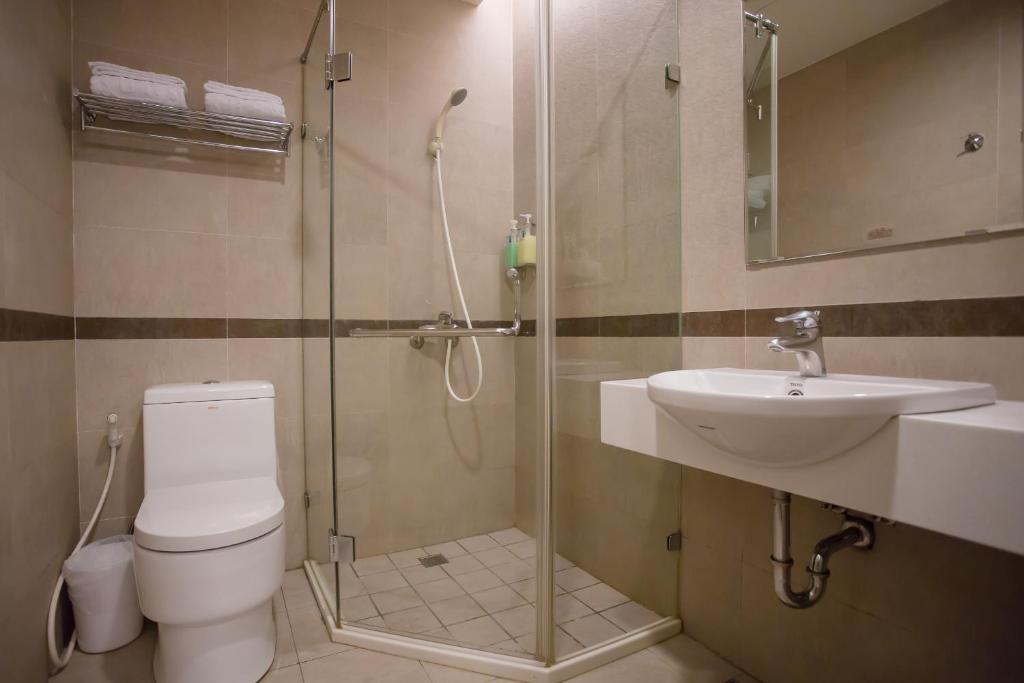 a bathroom with a shower and a toilet and a sink at Garden Hotel in Taichung