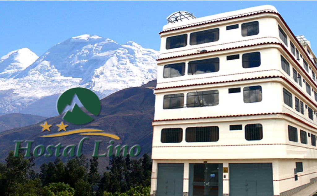 a building with a mountain in the background at Hostal Residencial Lino in Huaraz