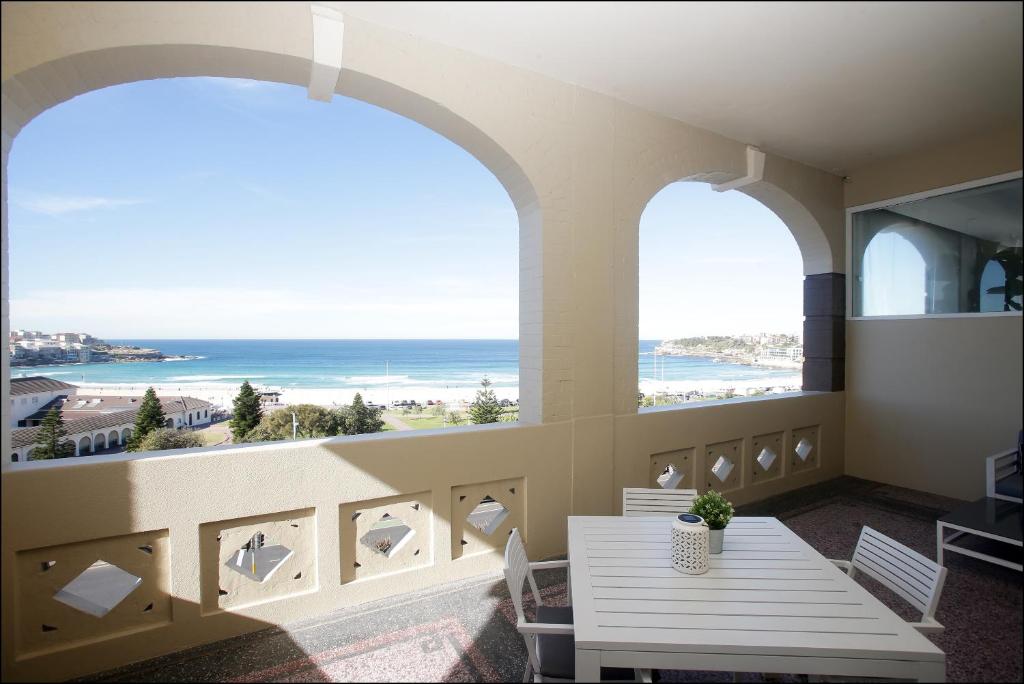 a dining room with a balcony overlooking the ocean at Hotel Bondi in Sydney