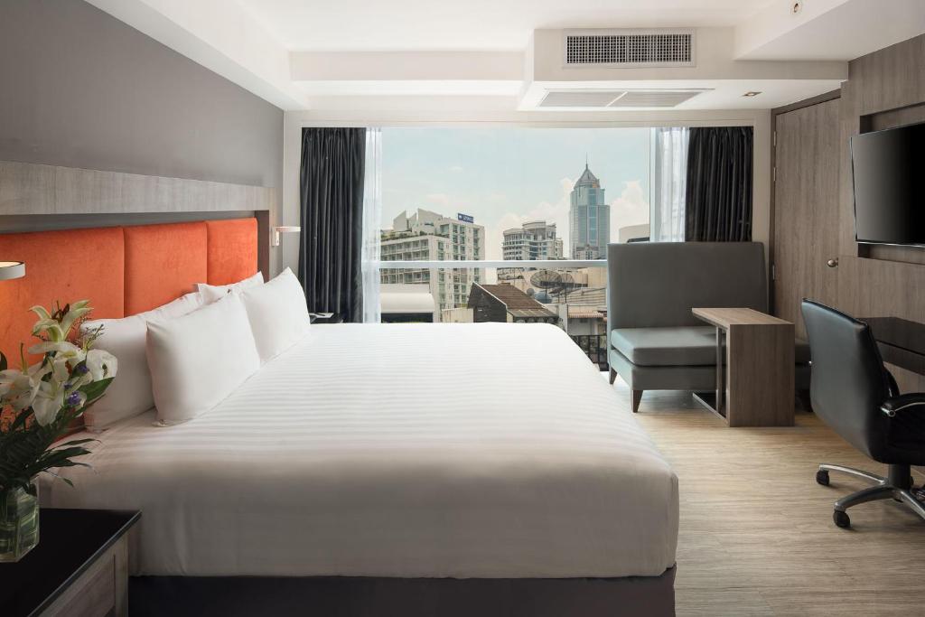 Säng eller sängar i ett rum på Grand 5 Hotel & Plaza Sukhumvit Bangkok