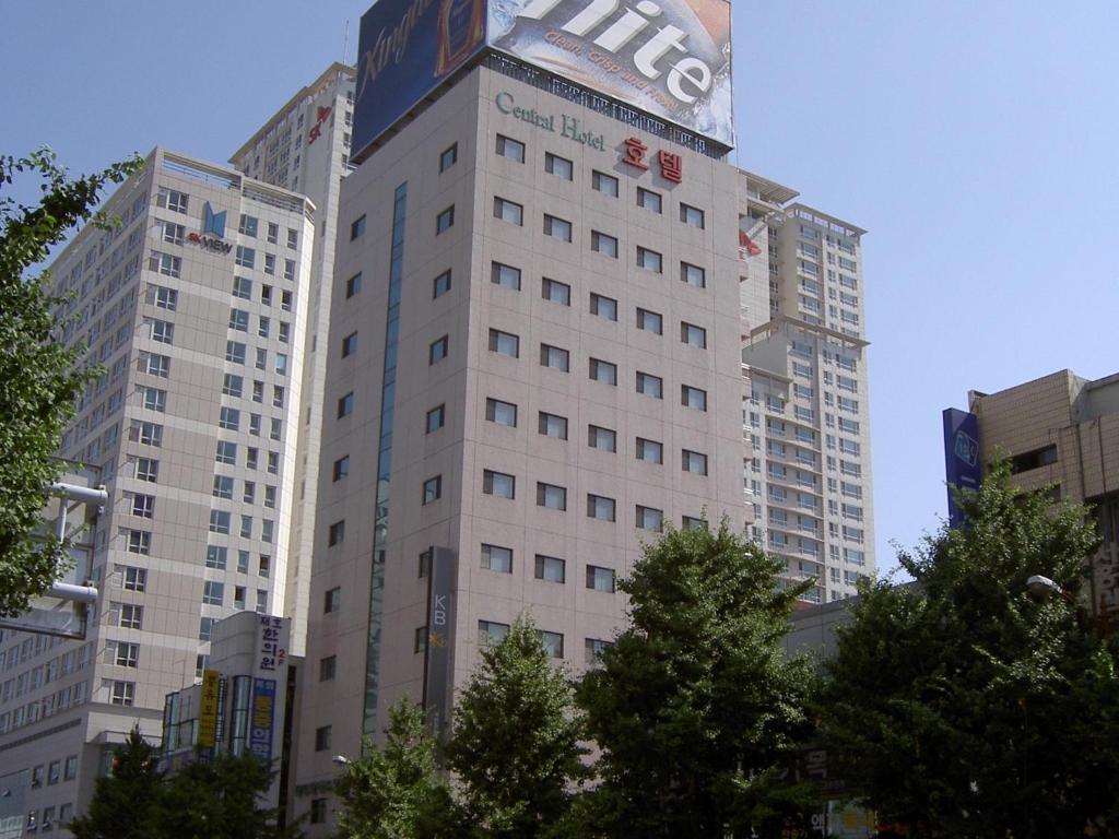 Busan Central Hotel في بوسان: مبنى أبيض طويل مع علامة عليه
