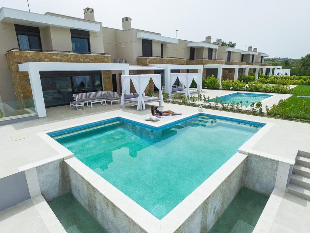 a swimming pool in front of a house at Bellevue Villas with private pool in Hanioti