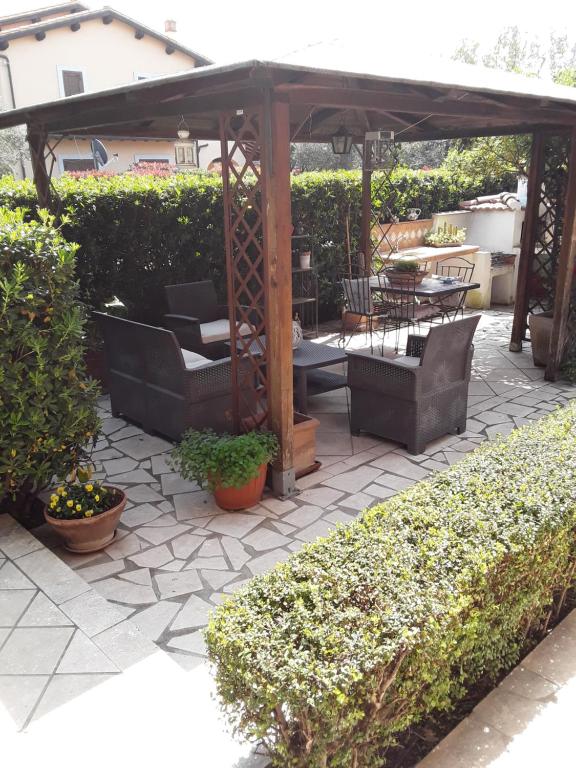eine Terrasse mit einem Pavillon, Stühlen und Pflanzen in der Unterkunft Capalbio Vacanze in Capalbio