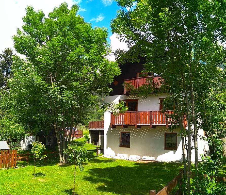 a white house with red balconies and trees at Appartement Jana in Flattach