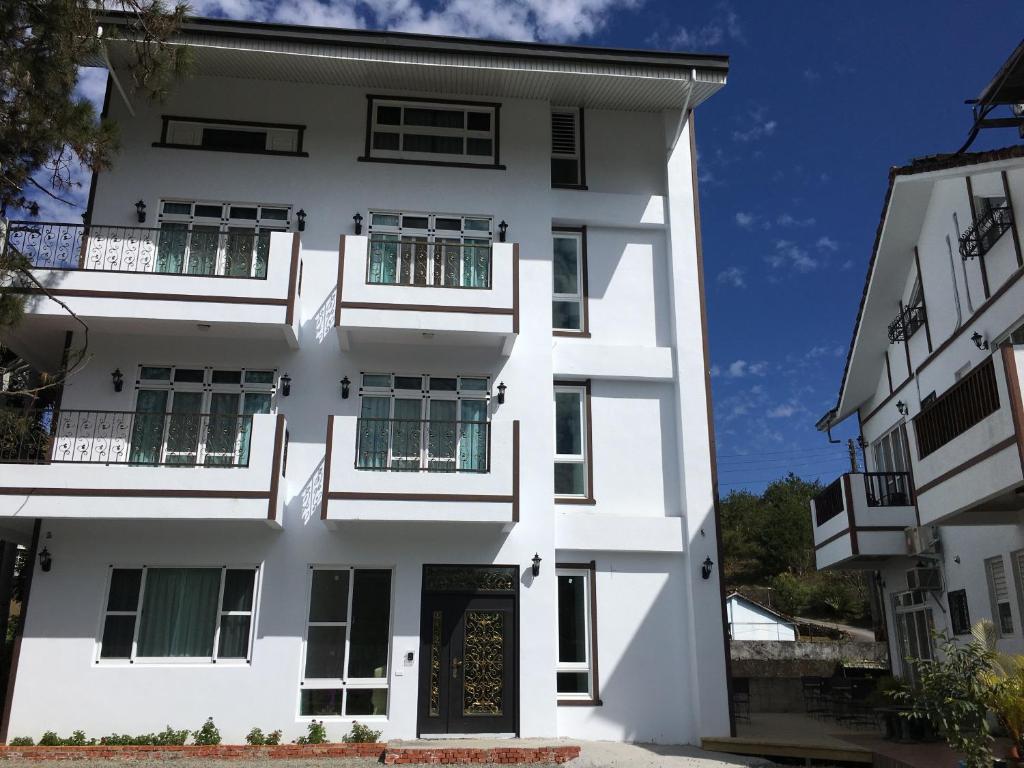 a white building with a door in front of it at Song Yue Homestay in Yuchi