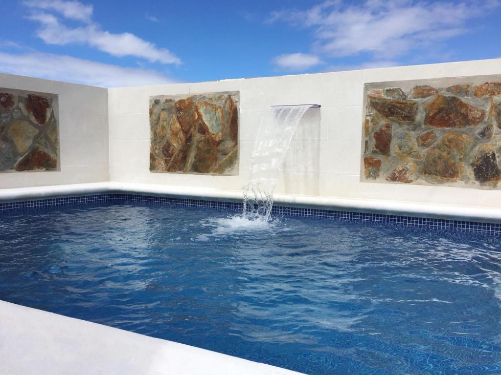 a swimming pool with a water fountain at Casa La Lomada in Telde