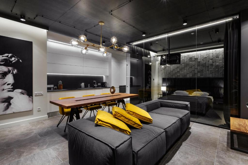 - un salon avec une table et des oreillers jaunes sur un canapé dans l'établissement Prestige Plaza Apartments, à Odessa