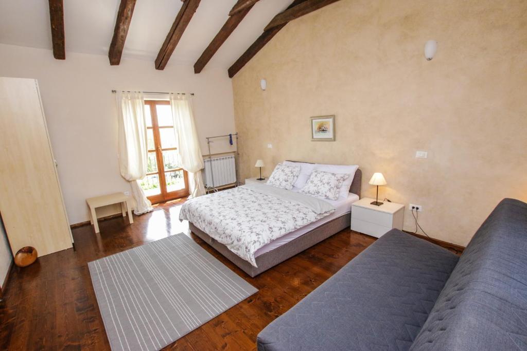 sypialnia z łóżkiem i kanapą w obiekcie Villa Marinac w Poreču