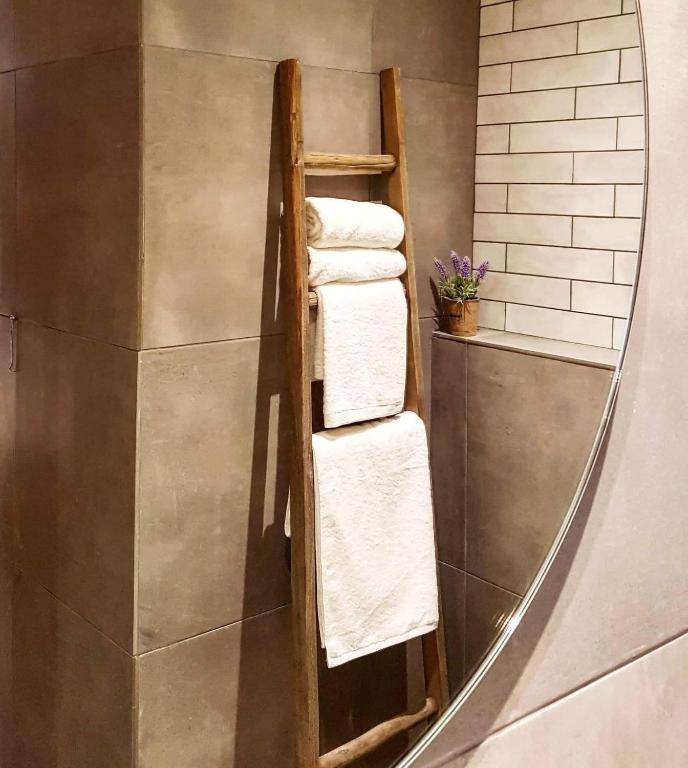 a mirror in a bathroom with towels on a shelf at Mougre studios in Polychrono