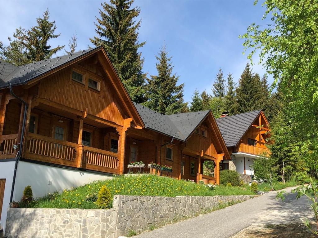 ein großes Holzhaus mit einer Veranda in der Unterkunft Glückliche Elfen in Sankt Kathrein am Hauenstein