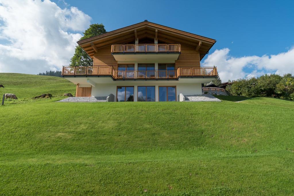 a house on top of a grassy hill at Das Hillside Maria Alm Hintermoos in Maria Alm am Steinernen Meer