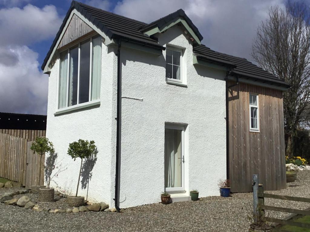 a white house with a wooden door at Burn View in Stronachlachar