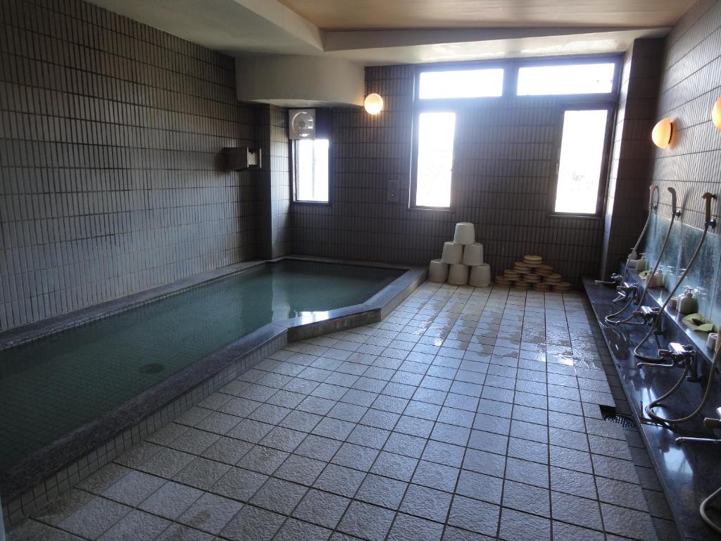 une salle de bain avec piscine dans une chambre dans l'établissement Jukeiso, à Miyajima