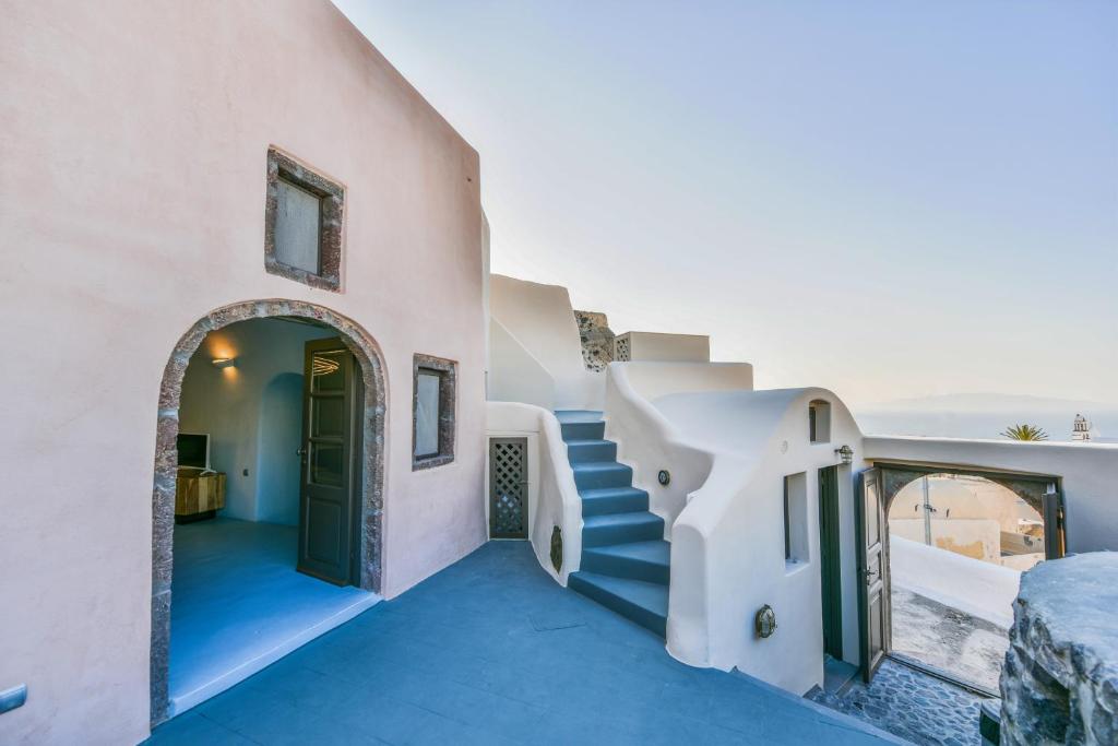 una scala che conduce a una casa con porta di Elia 1968 Cave Houses a Oia