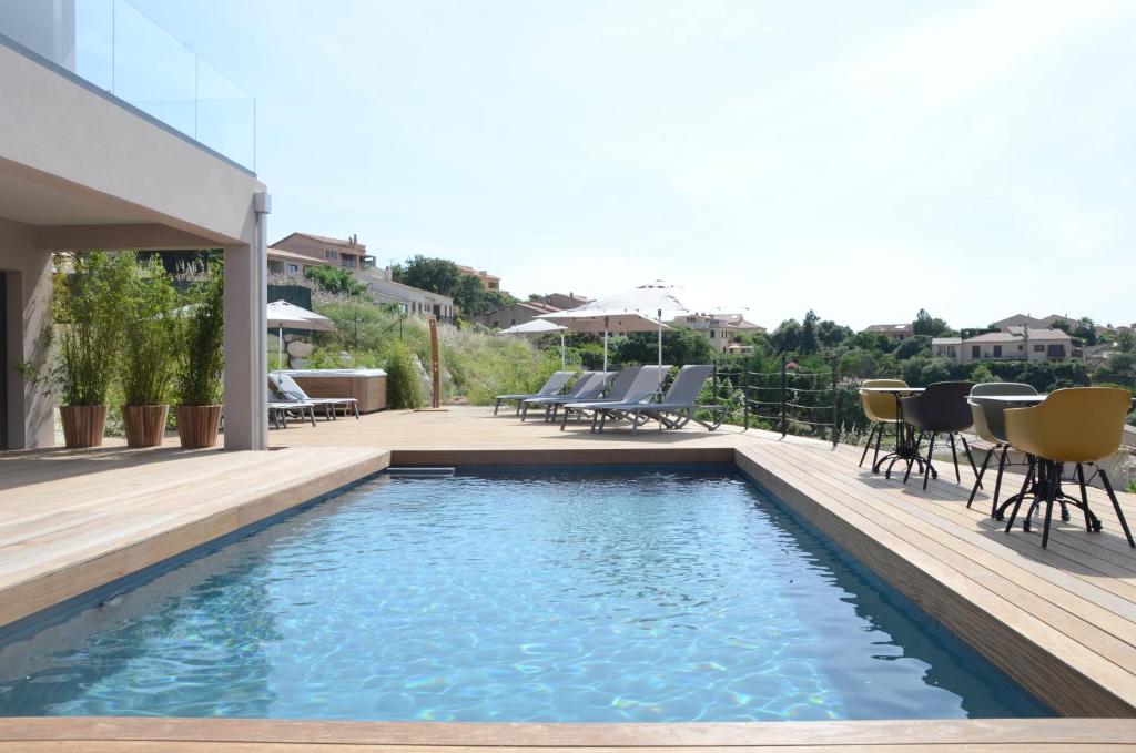 a swimming pool with chairs and tables on a house at Casa Mare E Vista in Propriano