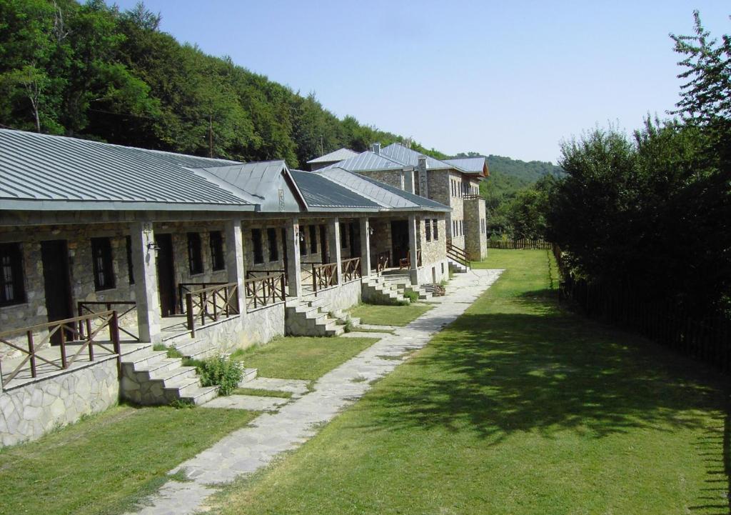 a row of buildings with a grassy yard in front at Manis Hotel in Nymfaio