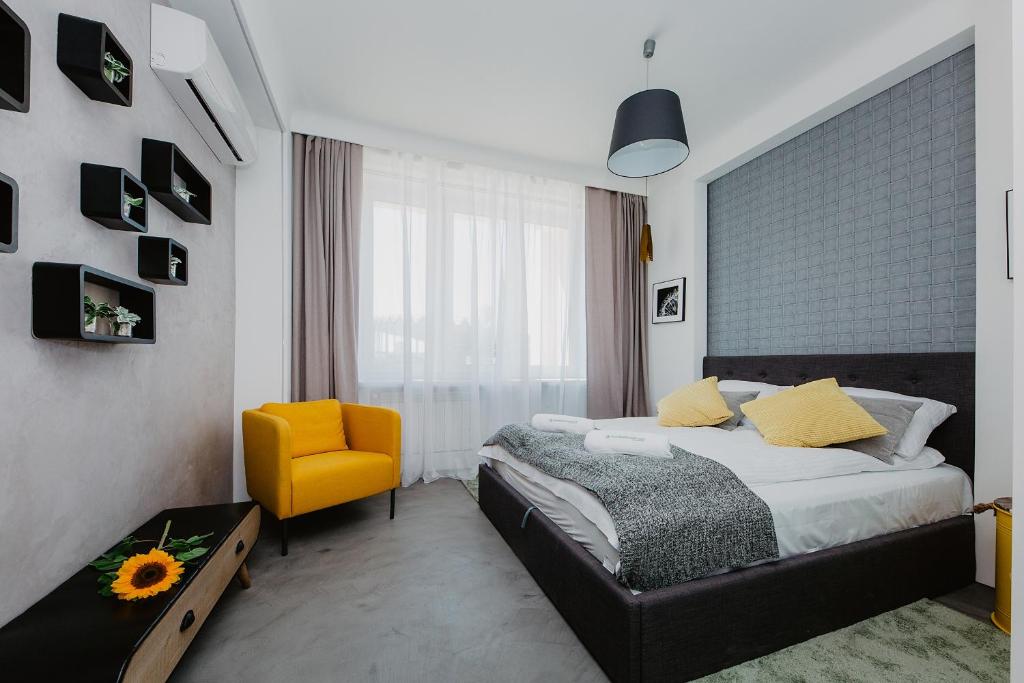 ワルシャワにあるShortStayPoland Aleje Jerozolimskie (B59)のベッドルーム1室(ベッド1台、黄色い椅子付)