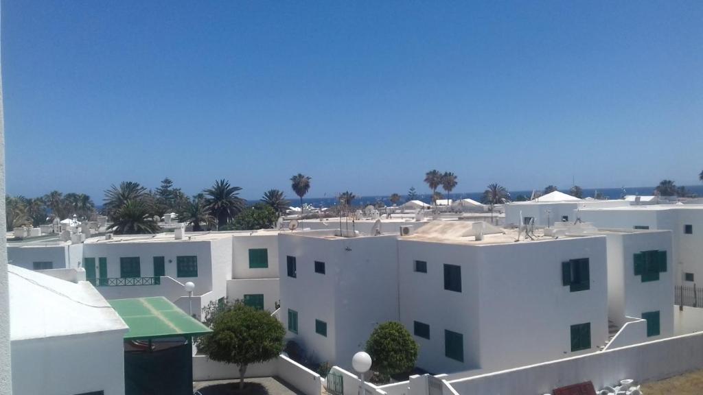a white building with palm trees in the background at Rubama in Puerto del Carmen