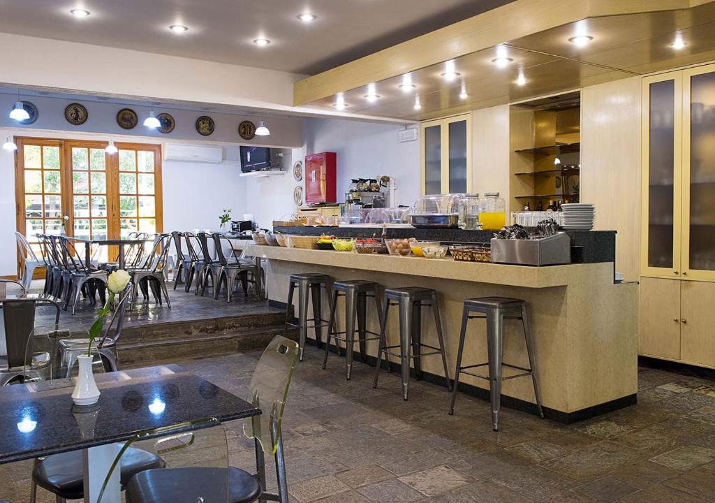 a kitchen with a counter and chairs in a restaurant at Stefanakis Hotel & Apartments in Varkiza