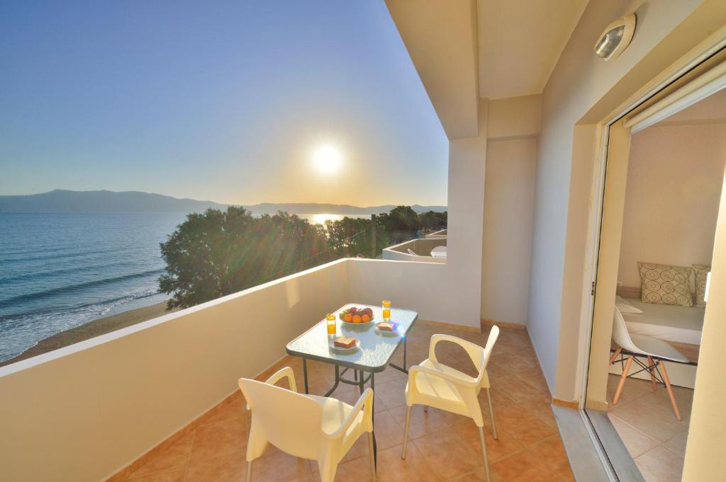 a balcony with a table and chairs and the ocean at Beach House in Kissamos
