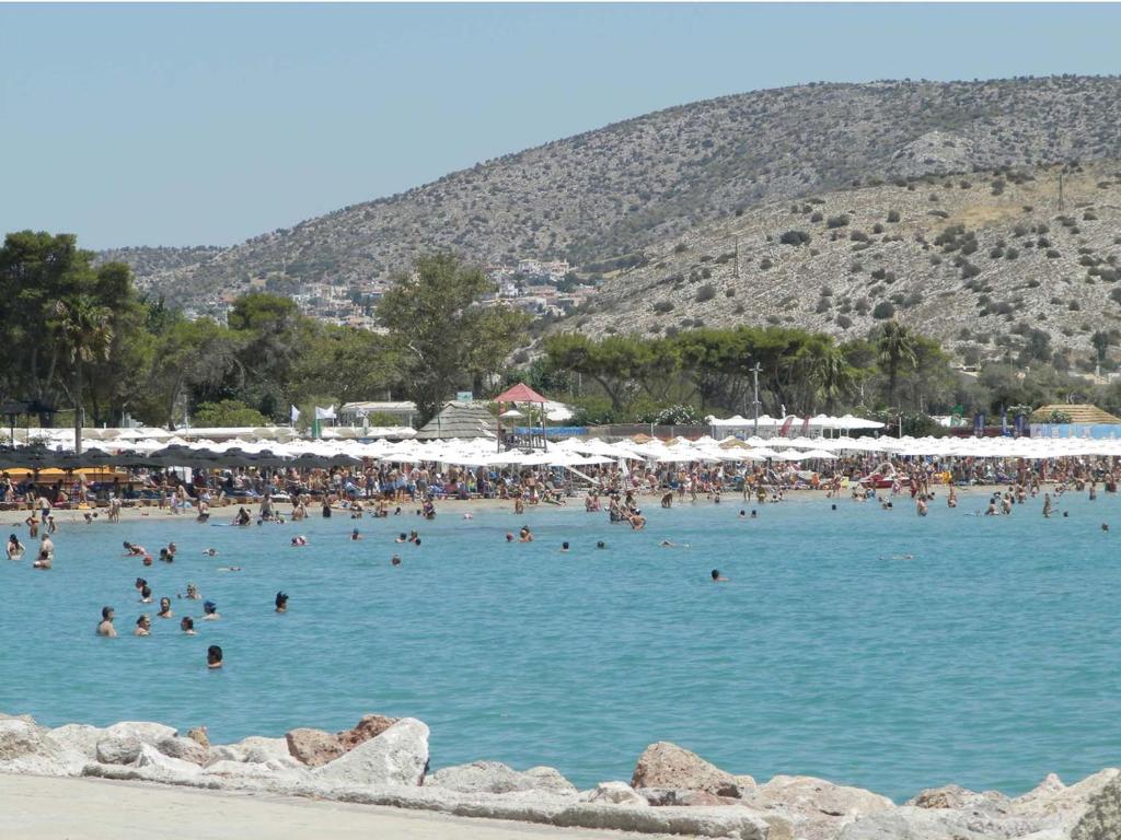 a group of people in the water at a beach at Stefanakis Hotel & Apartments in Varkiza
