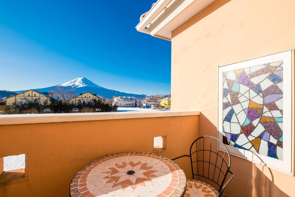 a balcony with a table and a view of a mountain at Villa Ensoleille in Fujikawaguchiko