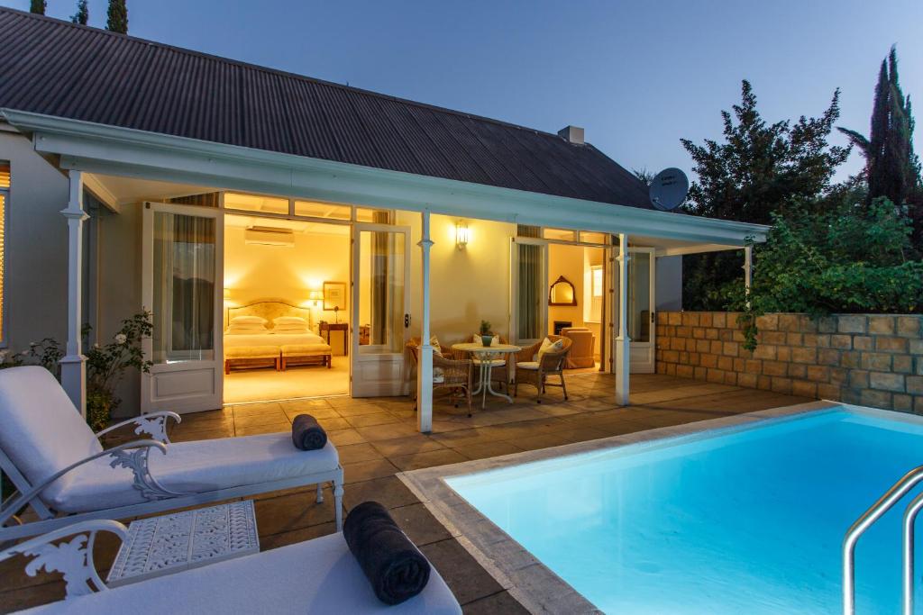 a house with a swimming pool and a bedroom at Rosenhof Boutique Hotel in Oudtshoorn