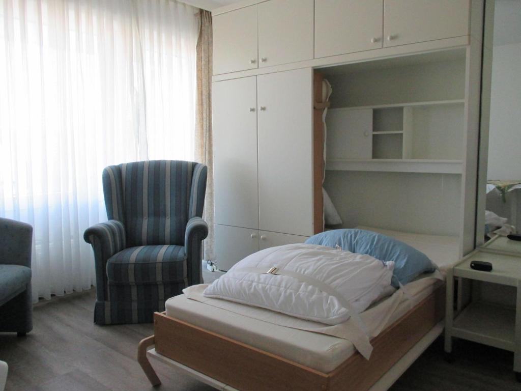 - une chambre avec un lit, une chaise et une chaise dans l'établissement Einzimmerappartement-fuer-zwei-Personen, à Westerland