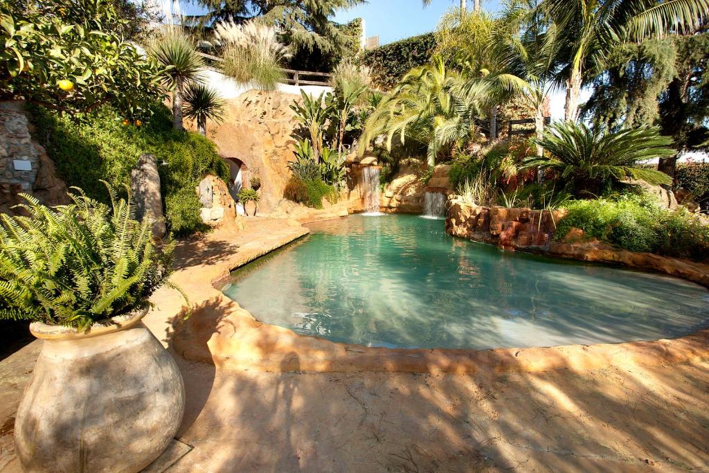 a swimming pool in a garden with palm trees at Mas Juli in Pineda de Mar