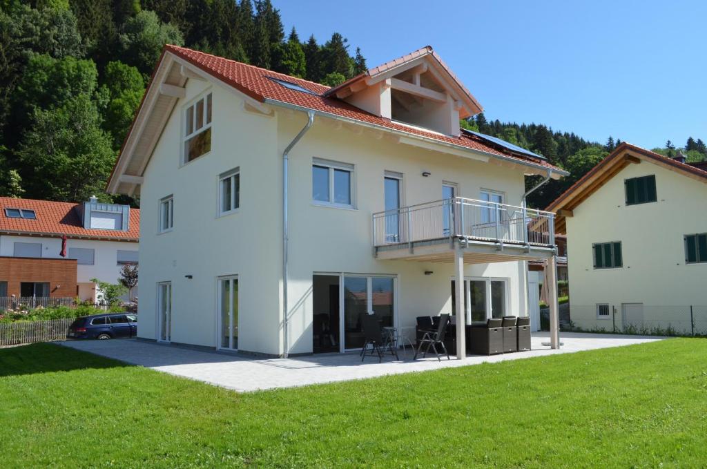 ein großes weißes Haus mit grünem Rasen in der Unterkunft Ferienhaus Luca in Füssen
