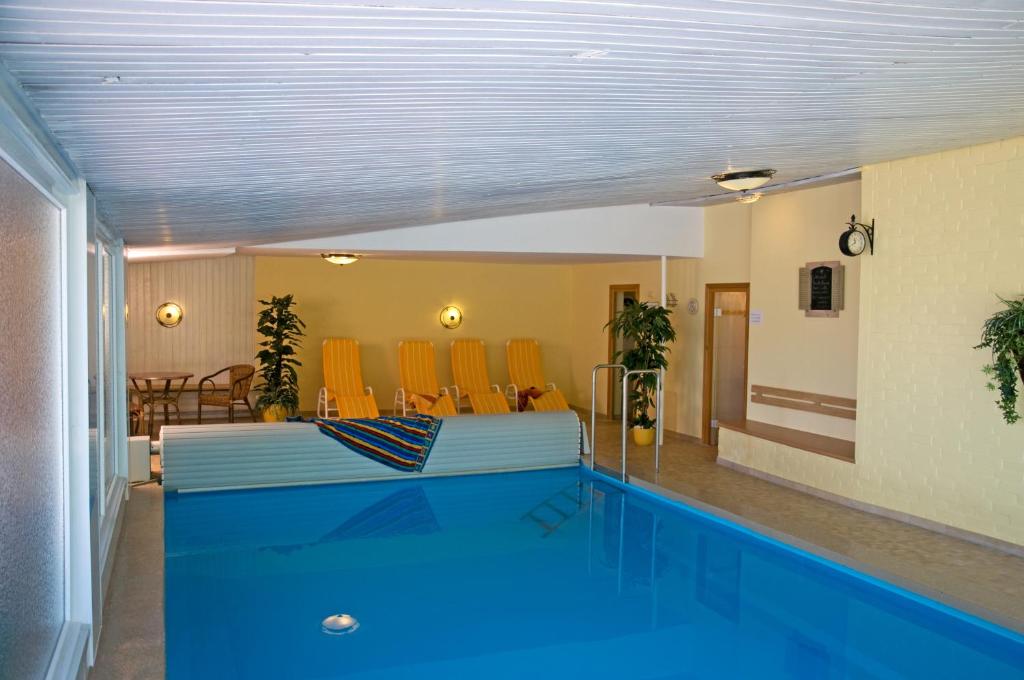 a swimming pool in a room with a swimming pool at Café und Pension Höpen Idyll in Schneverdingen