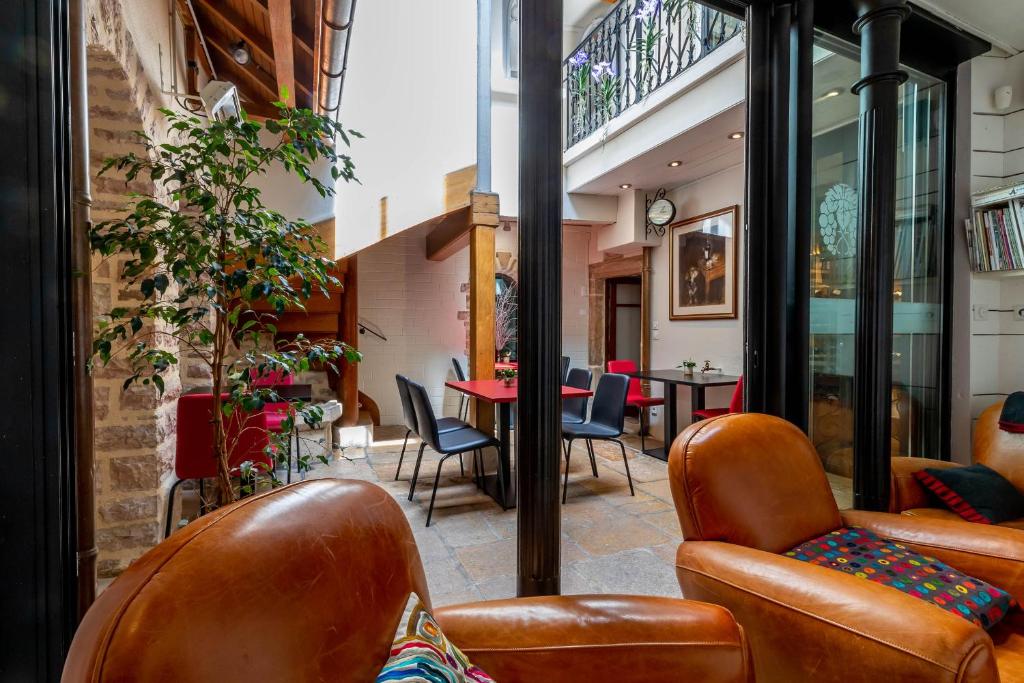 een woonkamer met lederen stoelen en een tafel bij La Maison de Maurice in Beaune