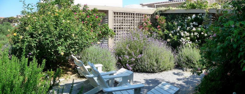 a garden with two white chairs and flowers at Red Tractor Farm in Korissia