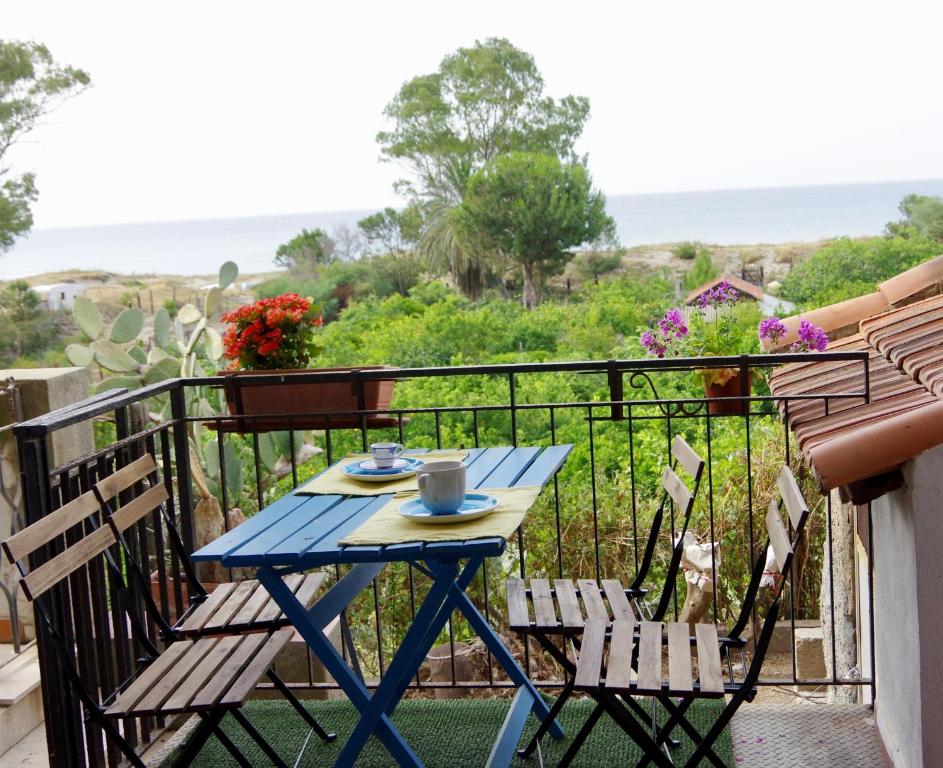 een blauwe tafel en stoelen op een balkon bij Casa sulla Spiaggia- Mortelle in Messina