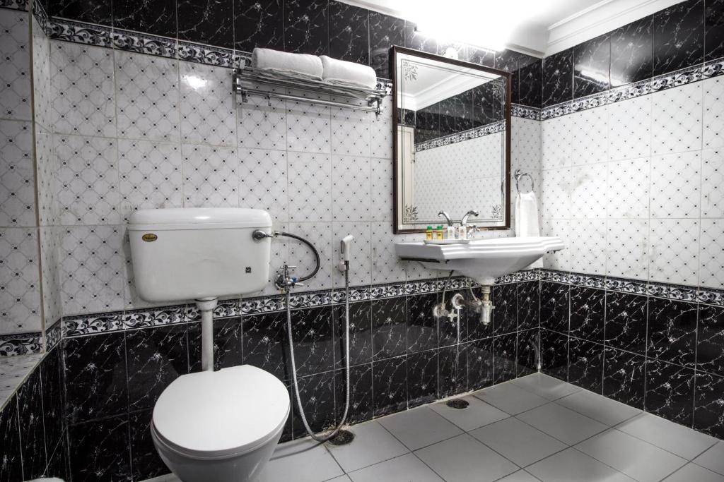 uma casa de banho em preto e branco com um WC e um lavatório em Hotel Sugan Niwas Palace em Jaipur