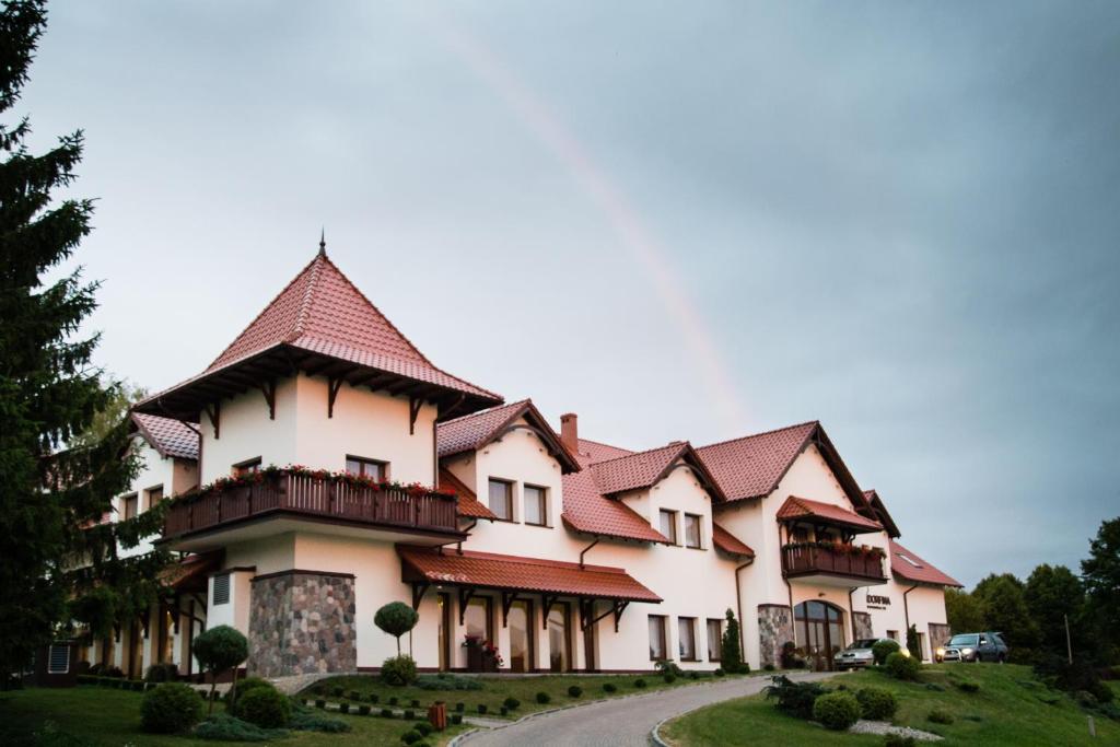 uma casa grande com uma torre numa estrada em Hotel Ventus Natural & Medical Spa em Goldap