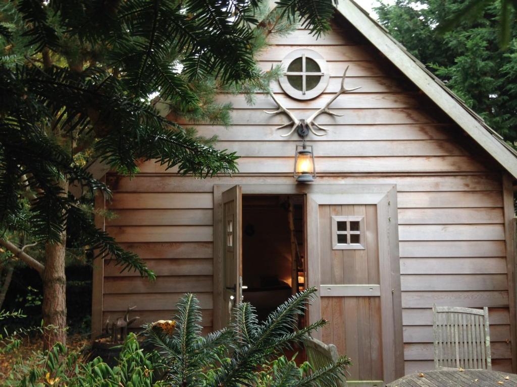 a small wooden cabin with a door and a window at Les Roulottes de la Baronnie in Saint Malo